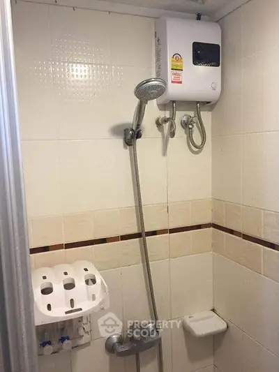 Compact bathroom with shower and water heater, ideal for efficient space use.