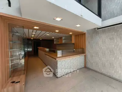 Spacious commercial space with modern wooden interior and ample lighting, ideal for retail or office use.