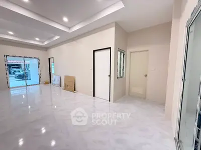 Spacious modern living room with sleek flooring and large windows for natural light.