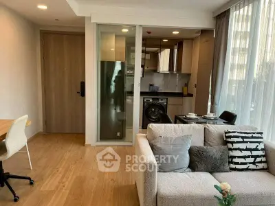 Modern living room with open kitchen, featuring cozy sofa and dining area, ideal for urban living.