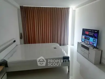 Modern bedroom with sleek design and large TV, ideal for contemporary living.