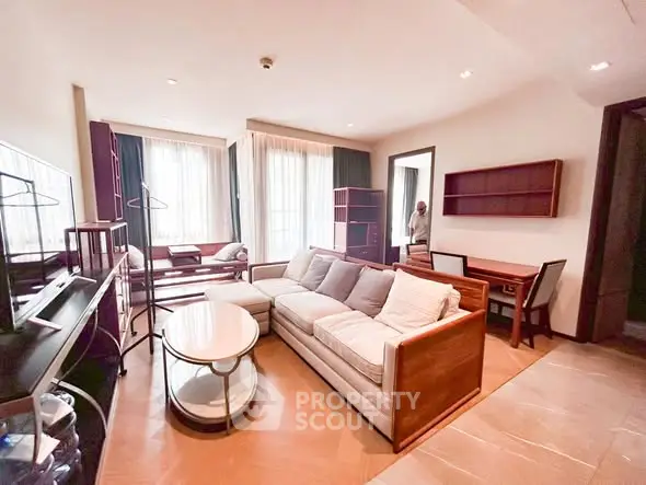 Spacious living room with modern furniture and natural light in a stylish apartment.