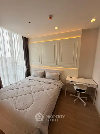 Modern bedroom with stylish decor and natural light, featuring a cozy bed and a compact study desk.