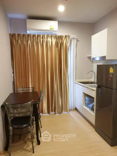 Modern compact kitchen with dining area and sleek appliances in cozy apartment