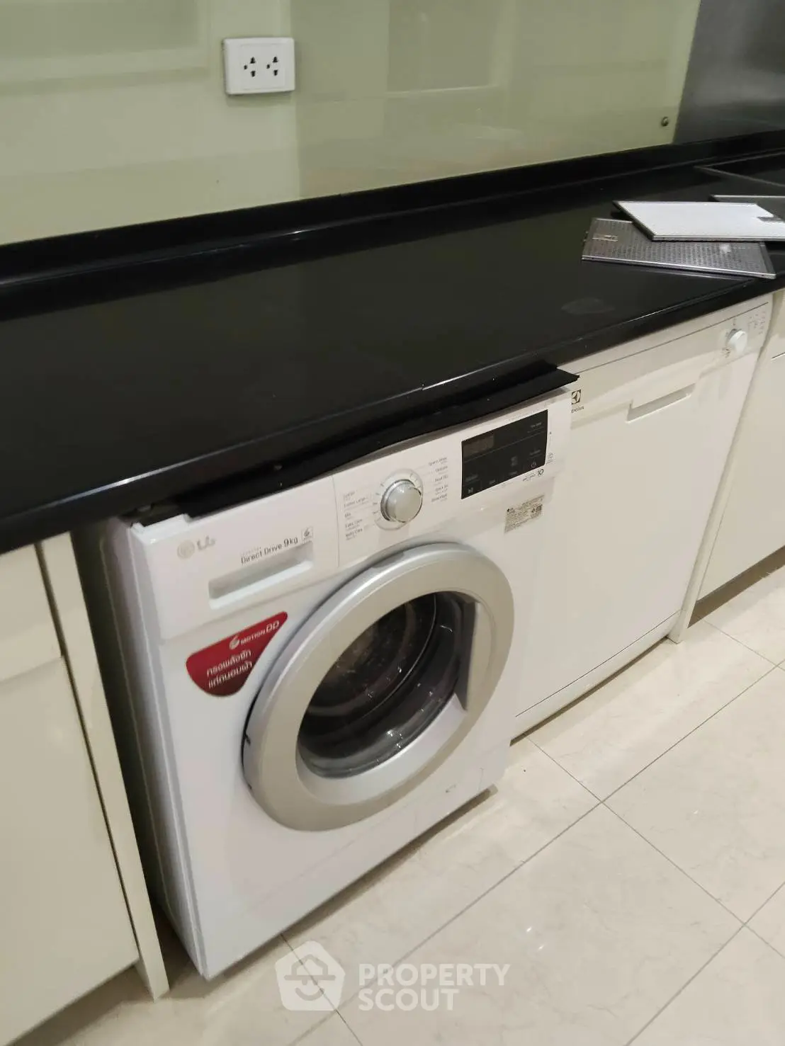 Modern kitchen with sleek appliances including a washing machine and dishwasher, perfect for convenient living.