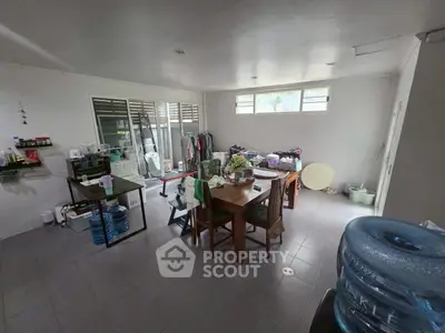 Spacious kitchen with dining area and ample natural light, featuring modern appliances and tiled flooring.