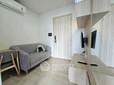 Modern living room with sleek furniture and wall-mounted TV in a cozy apartment.