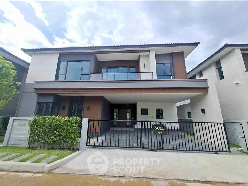 Modern two-story house with sleek design and spacious driveway, perfect for family living.