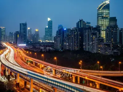Stunning cityscape view with illuminated skyscrapers and busy highway at dusk.