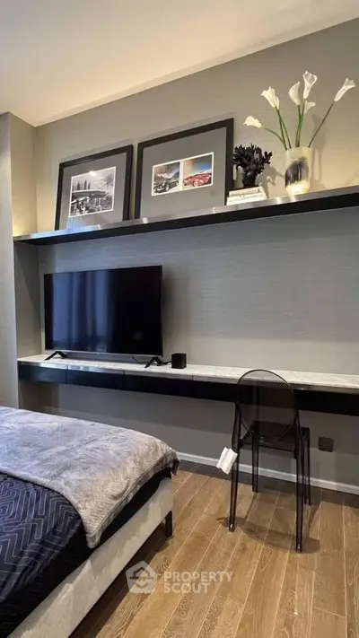 Modern bedroom with sleek decor, wall-mounted TV, and stylish shelving.