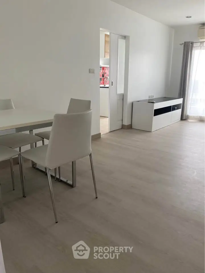Modern minimalist dining area with sleek white furniture and natural light