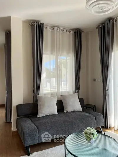 Chic living room with modern gray sofa and elegant curtains, perfect for cozy relaxation.