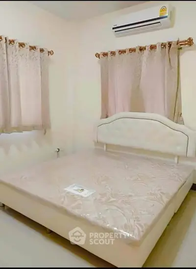 Cozy bedroom with elegant curtains and air conditioning, perfect for restful nights.
