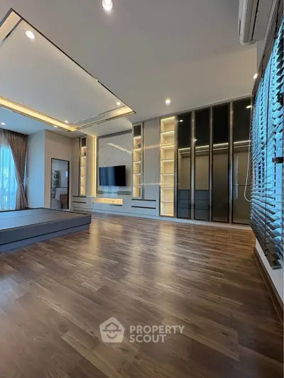 Spacious modern living room with elegant wooden flooring and built-in storage
