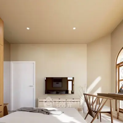 Modern bedroom with TV and stylish furniture, featuring natural light and elegant decor.