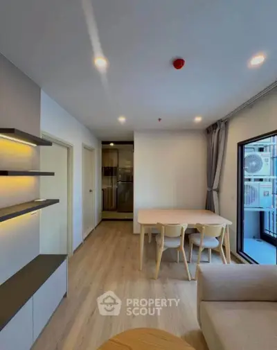 Modern living room with stylish furniture and large window leading to balcony.