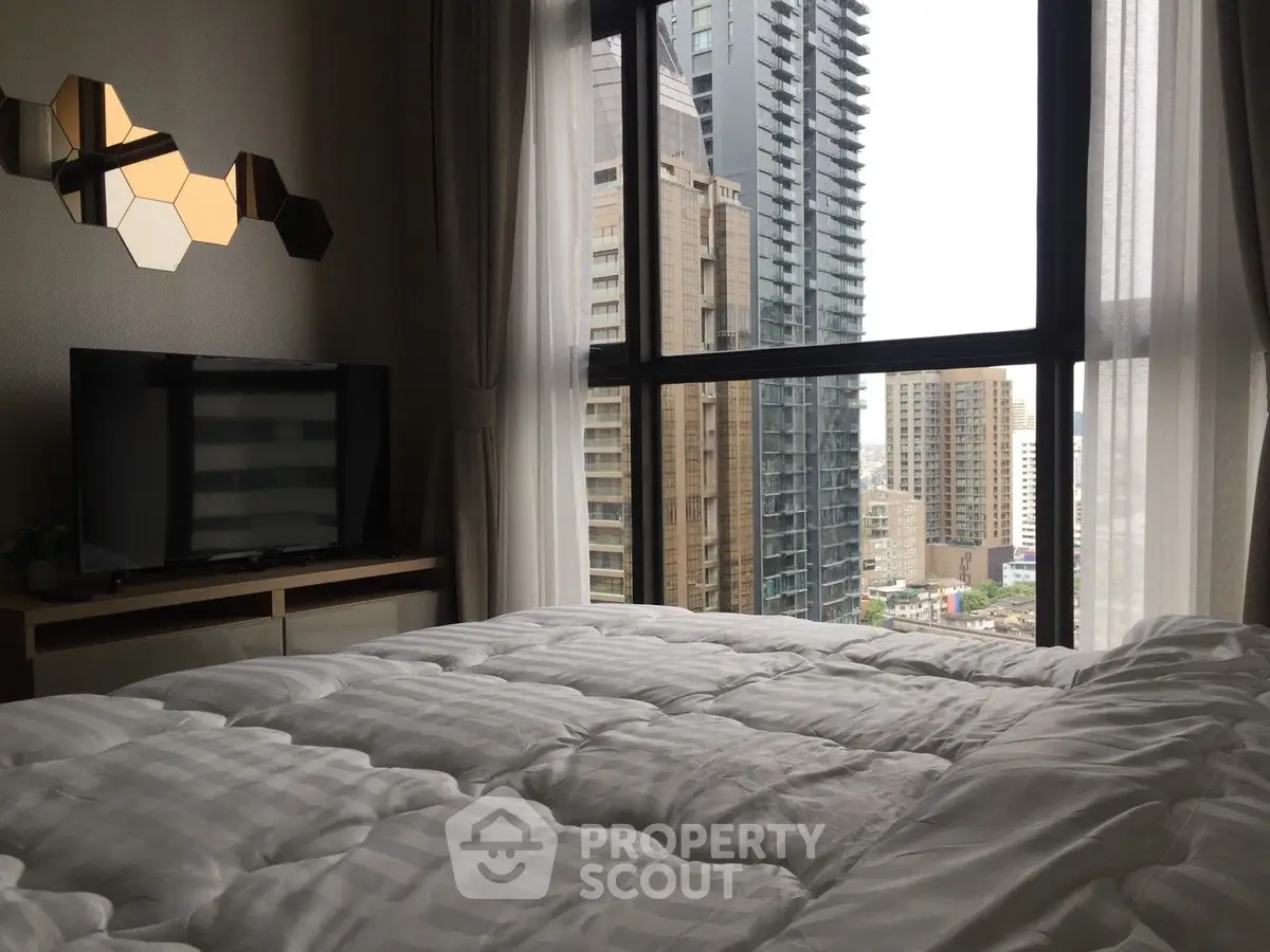 Luxurious bedroom with stunning city view and modern decor in high-rise apartment.