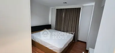 Cozy bedroom with wooden flooring and modern design in a stylish apartment.