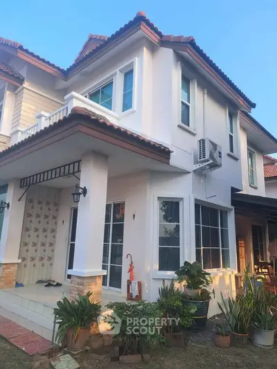 Charming two-story house with lush garden and modern exterior design.