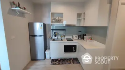 Modern kitchen with sleek white cabinets and stainless steel appliances in a compact layout.