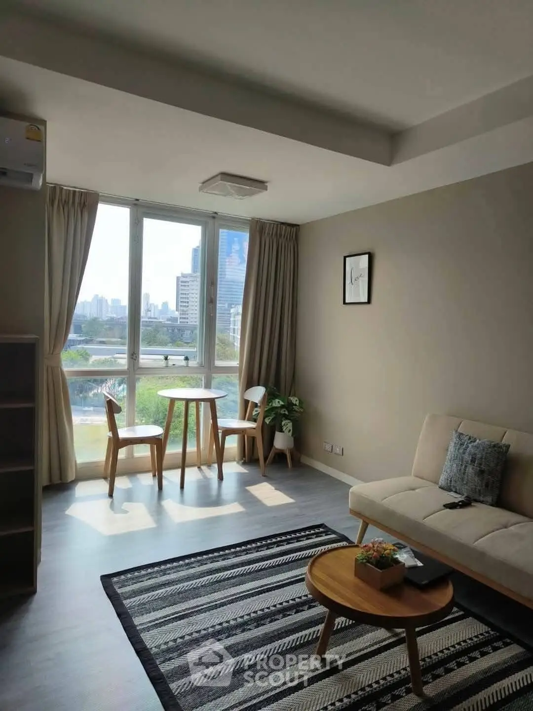 Bright living room with city view, modern furniture, and large window.