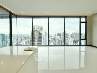 Luxurious high-rise apartment with stunning city skyline view through floor-to-ceiling windows.