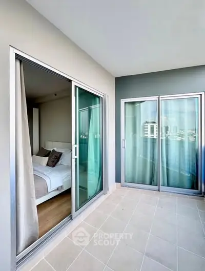 Spacious balcony with sliding glass doors and city view, perfect for relaxation and enjoying the skyline.
