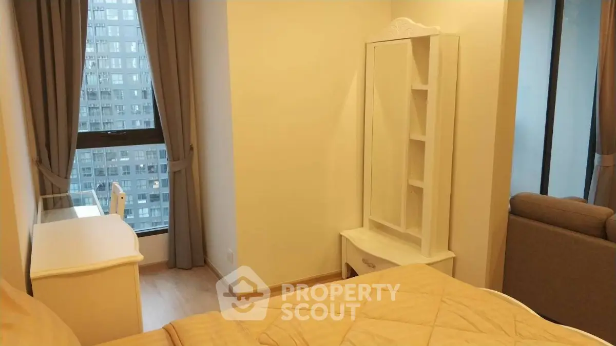 Cozy bedroom with elegant furnishings and city view window in modern apartment.