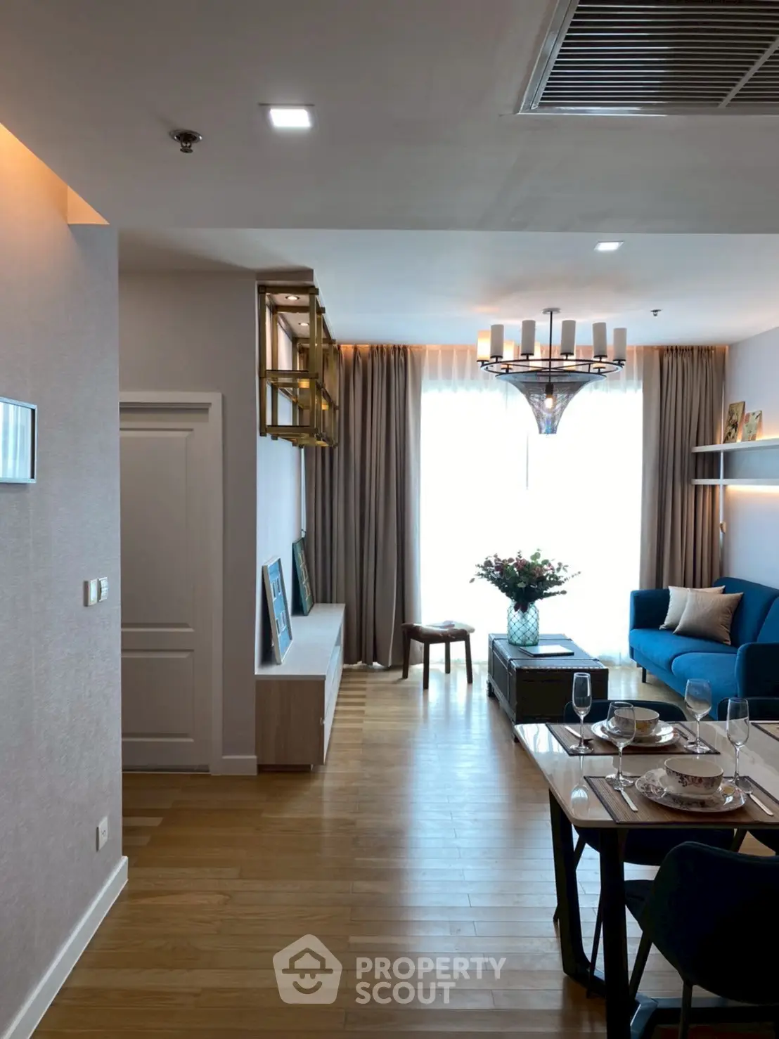 Modern living room with elegant decor and natural light, featuring a stylish dining area and cozy seating.