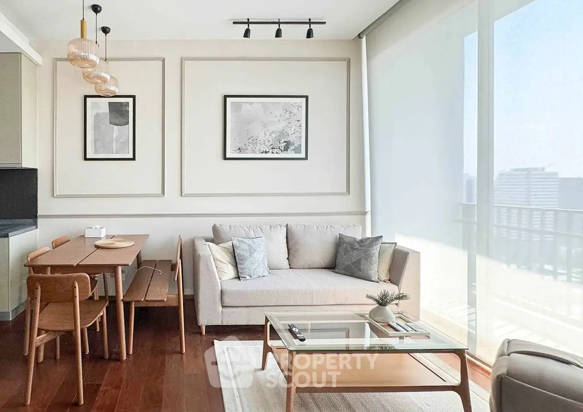Modern living room with elegant decor and natural light, featuring a cozy sofa and stylish dining area.
