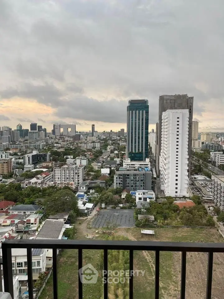 Stunning cityscape view from high-rise balcony, showcasing urban skyline and lush greenery.
