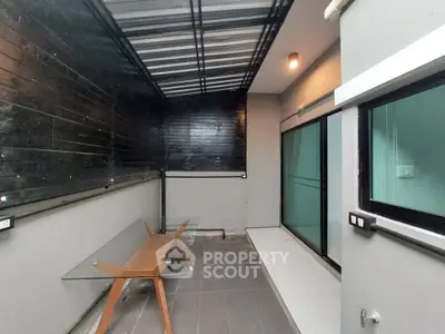 Modern balcony with glass table and sleek design, perfect for urban living.