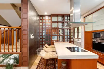 Modern kitchen with sleek design, featuring an island cooktop and stylish bar stools.