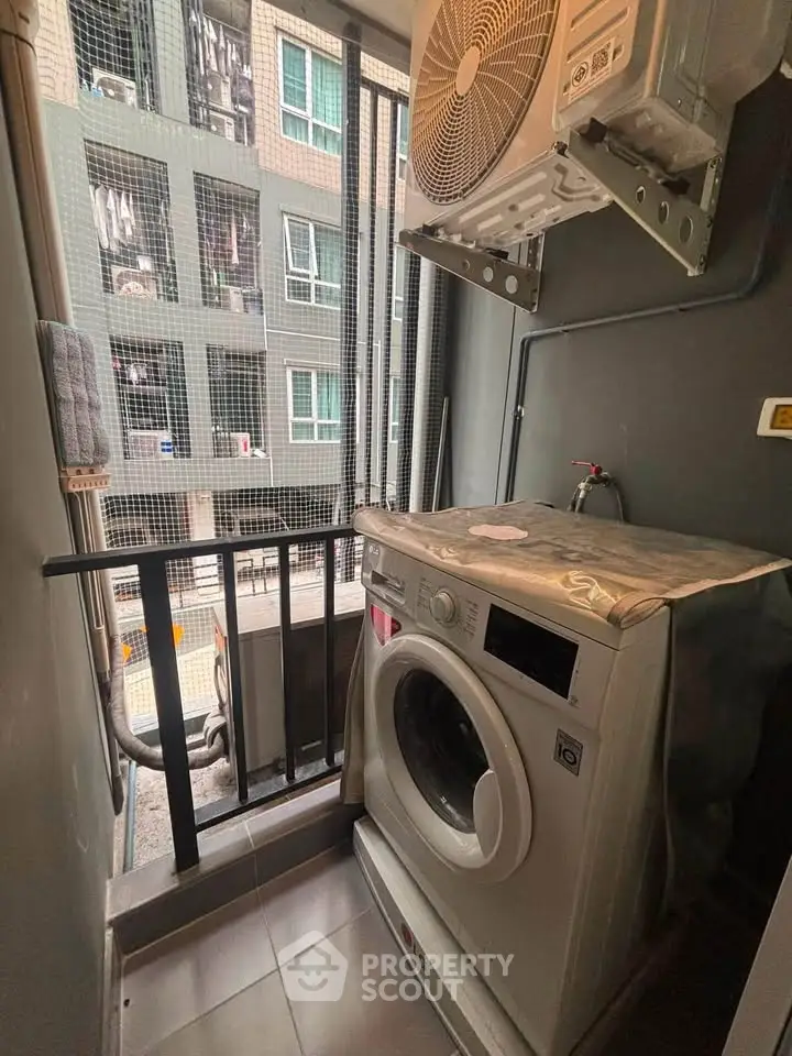 Compact laundry area with washing machine and air conditioning unit in modern apartment balcony.