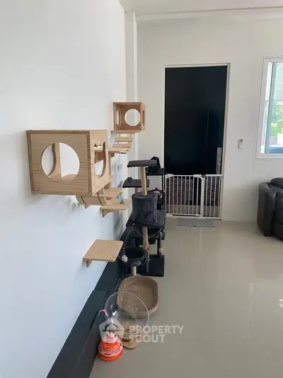 Modern living room with cat play structures and sleek flooring