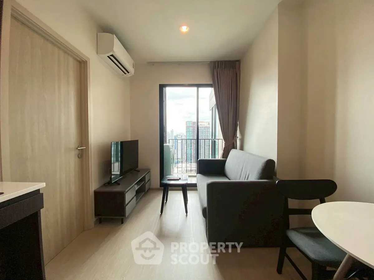 Modern living room with balcony view, sleek furniture, and natural light.