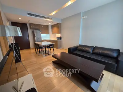 Modern living room with sleek furniture and open kitchen layout in a stylish apartment.