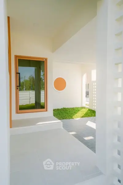 Modern home entrance with stylish design and lush green lawn