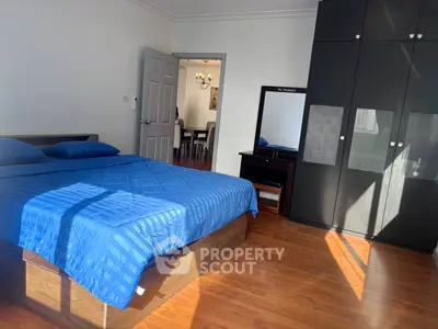 Spacious bedroom with blue bedding and ample natural light