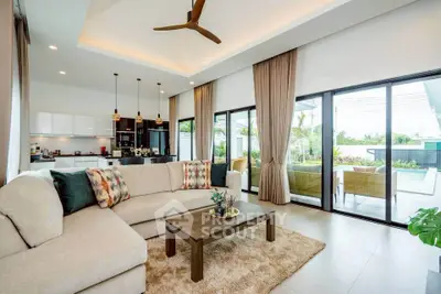 Luxurious open-plan living room with modern decor and poolside view