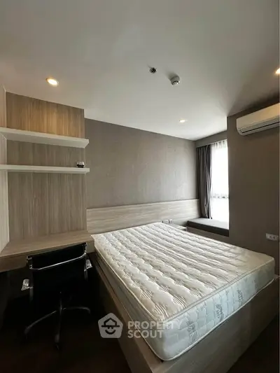 Modern bedroom with built-in desk and air conditioning, featuring a large window for natural light.