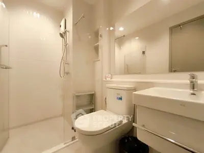 Modern bathroom with sleek fixtures and glass shower enclosure in a contemporary home.