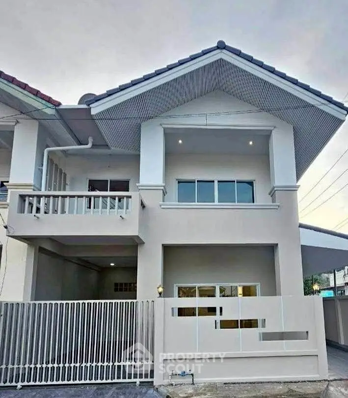 Modern two-story house with balcony and gated entrance, showcasing contemporary architecture and spacious design.