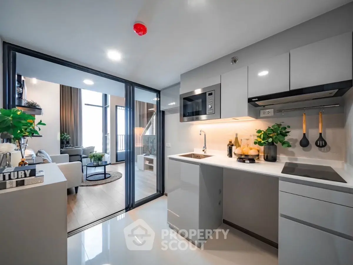 Modern open-layout kitchen with sleek design and spacious living area.