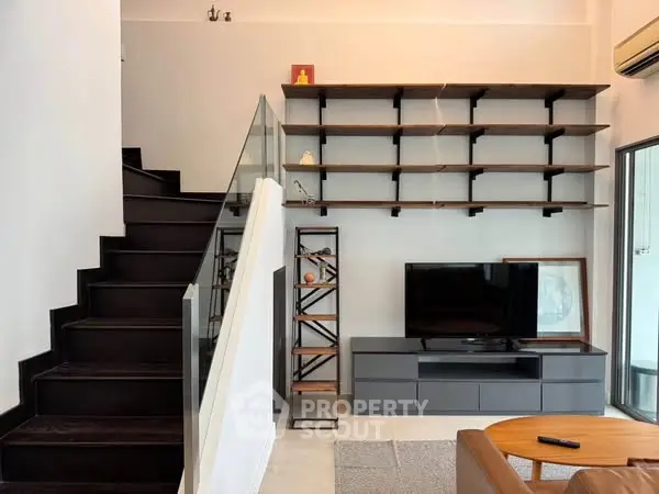 Modern living room with sleek staircase and stylish shelving unit