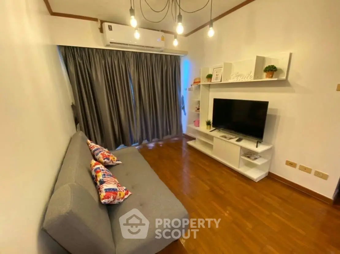 Cozy living room with modern decor, featuring a comfortable sofa, stylish shelving, and a flat-screen TV.