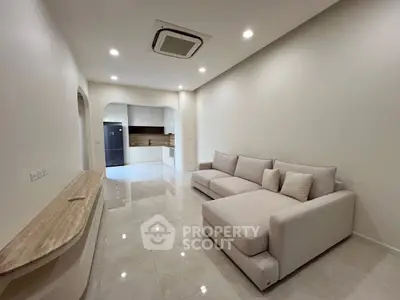 Spacious modern living room with elegant sofa and open kitchen layout