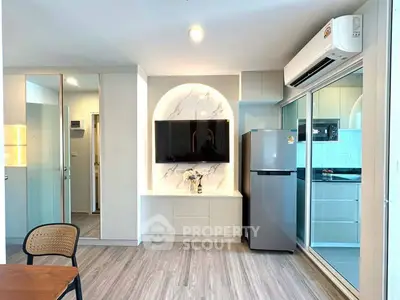 Modern living room with sleek TV setup and stylish kitchen view