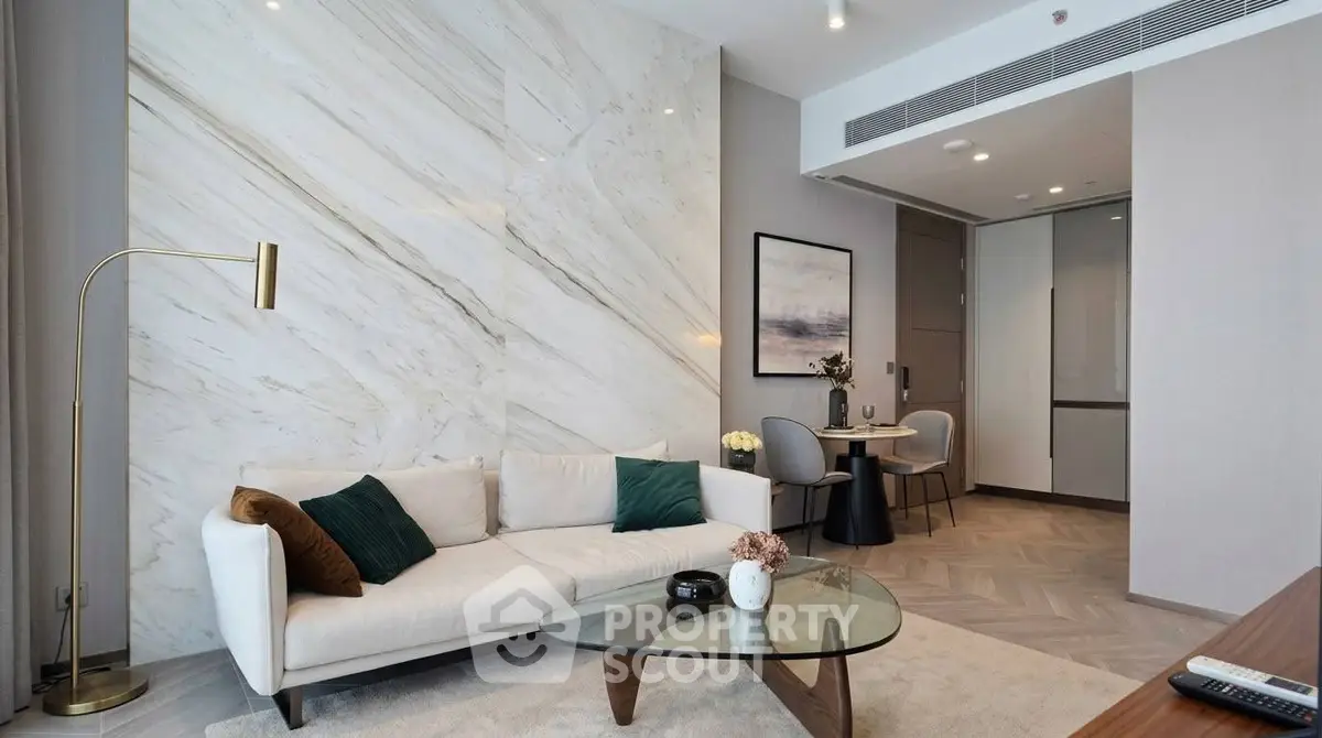 Elegant living room with modern decor and marble accent wall, featuring a cozy sofa and stylish coffee table.