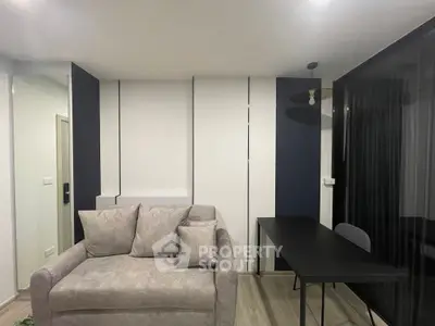 Modern living room with stylish sofa and sleek black desk in a contemporary apartment.